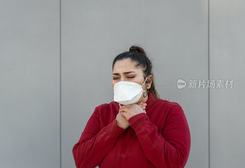 一名年轻女子在机场戴着医用口罩