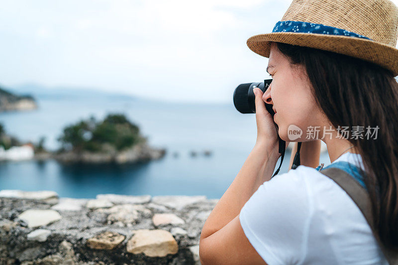 在海边拍摄照片的女人