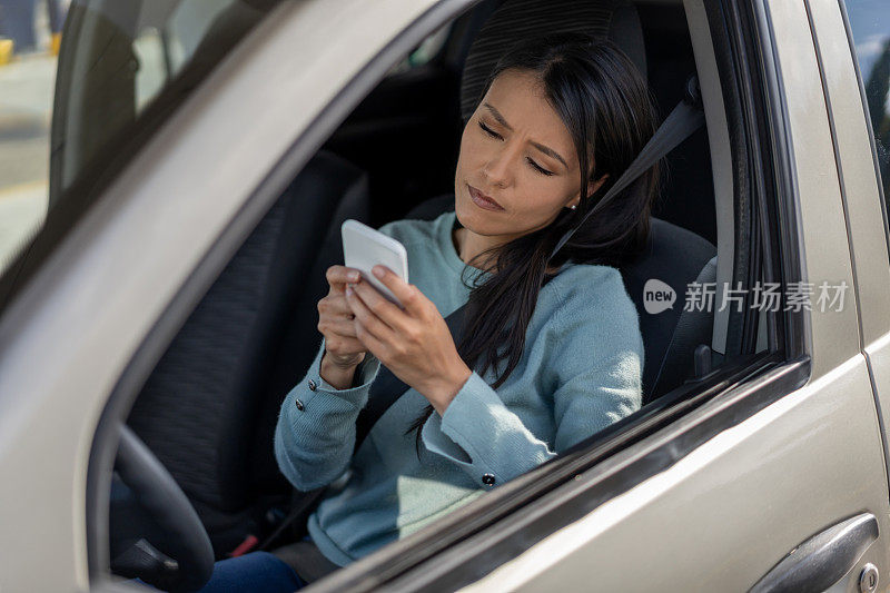 女人在车里用智能手机呼叫路边救援