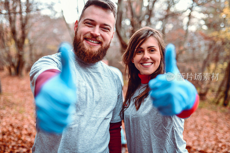 可爱的志愿者夫妇为森林垃圾清理竖起大拇指