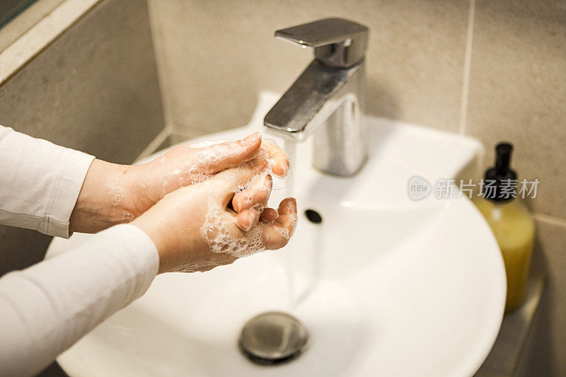 年轻女子用肥皂彻底洗手