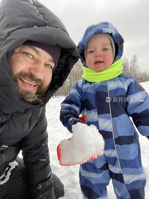 父子俩在户外玩雪时自拍