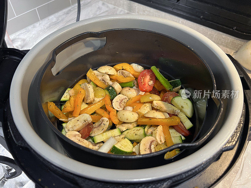 在空气炸锅中烹饪的混合蔬菜。