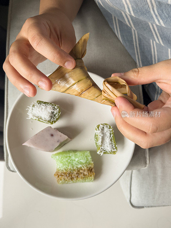 多种族的年轻女子打开传统的娘惹大米和豆类小吃