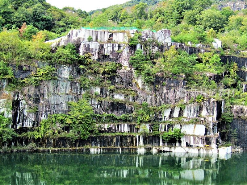 日本。山间小池塘周围的奇异岩石。