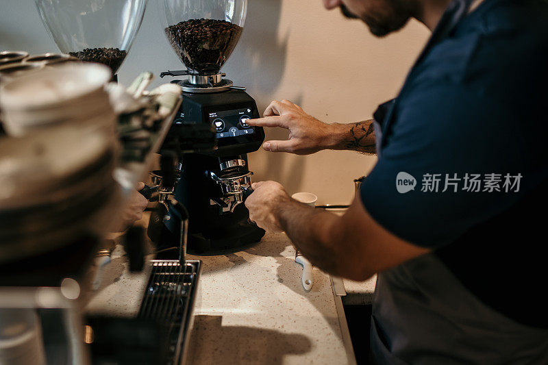 在舒适的咖啡馆里，咖啡师正在用浓缩咖啡机制作拿铁咖啡