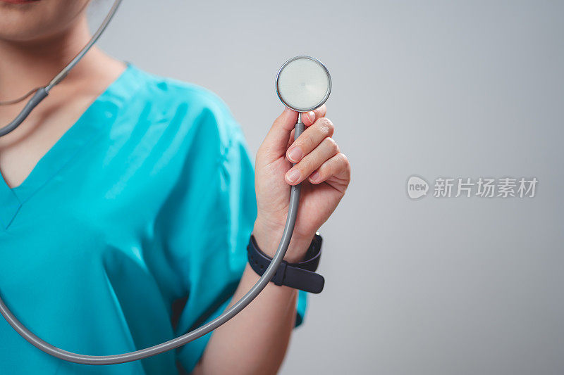 一个穿着医生制服的女人的特写镜头，医生快乐地微笑着，拿着听诊器，孤立在白色的背景上。
