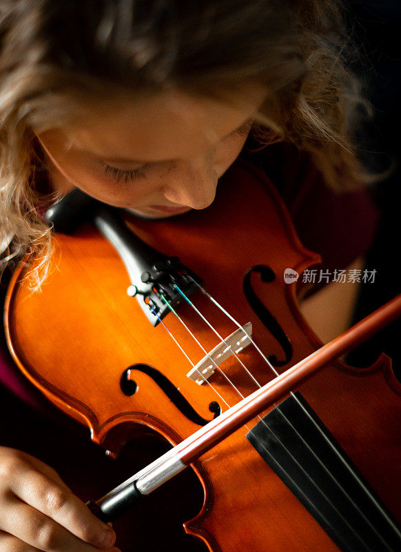 严肃的小学音乐家，女孩练习拉小提琴