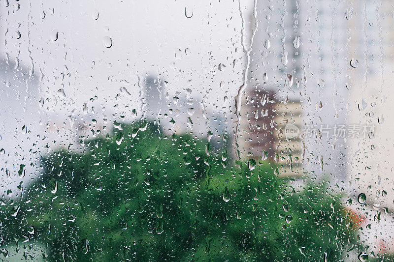 雨滴落在窗户上，背景