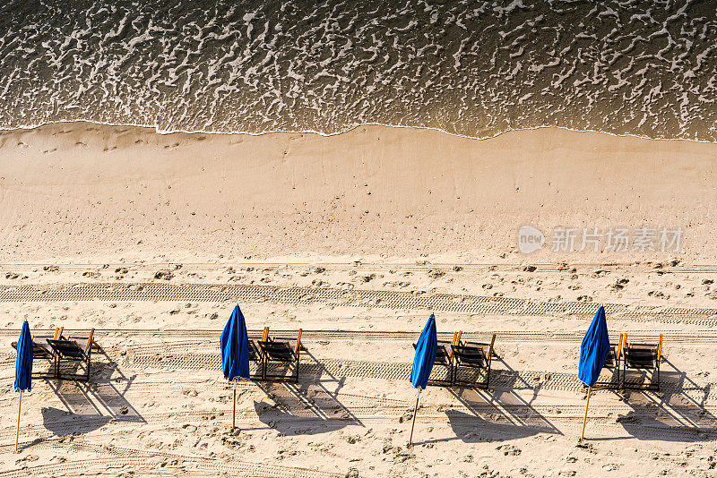沙滩椅、雨伞和海浪
