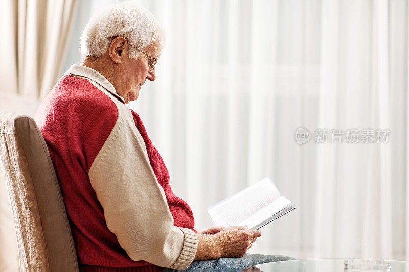 老人在家里看书。