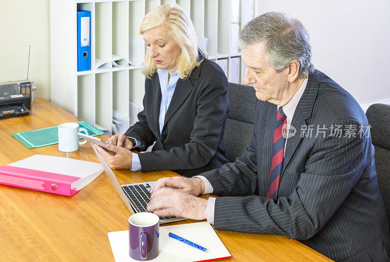 快乐的高级商务同事在办公桌旁开会，专注于男人。