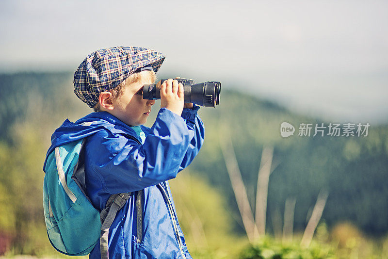 用双筒望远镜看的小徒步者