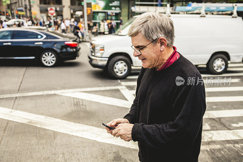 一个成熟的男人在纽约边走边发短信