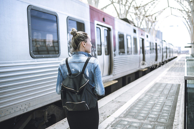 女子旅行者背包在火车站检查时间