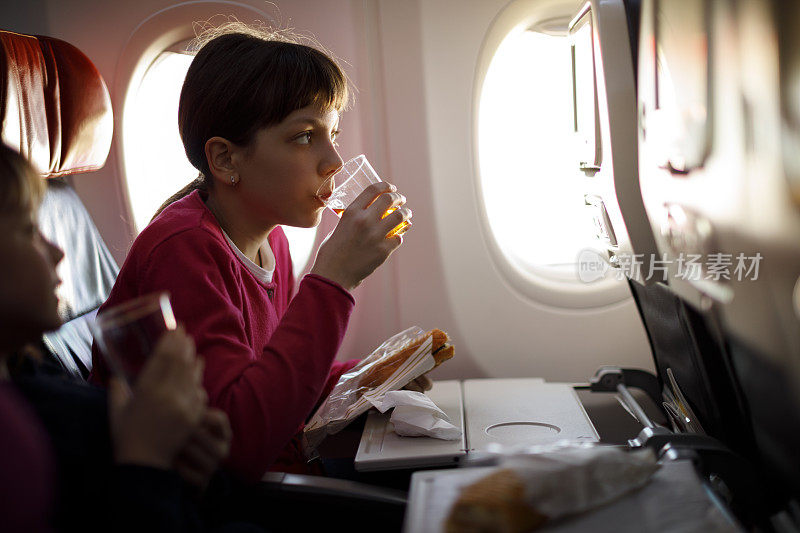 年轻女孩在飞机上吃饭