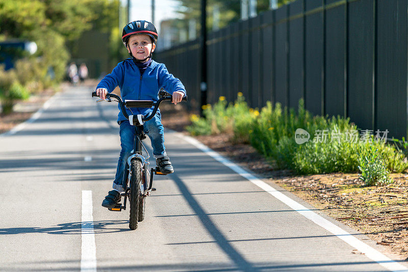 快乐的男孩在自行车道上骑自行车