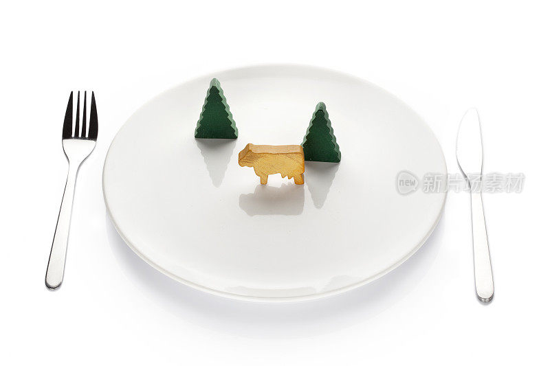 白色盘子上的木制玩具牛
