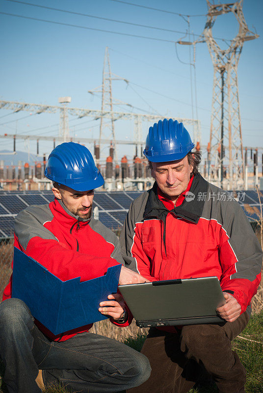 技术人员，工程师和太阳能电池板上的笔记本电脑