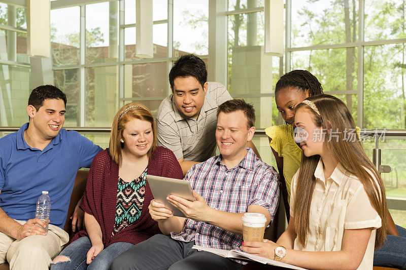 不同年龄的大学生朋友在校园里分享平板电脑。