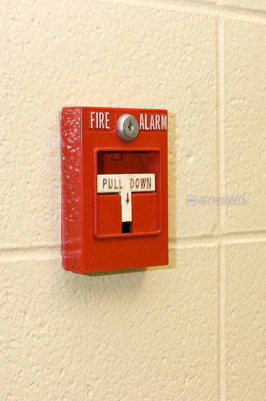 混凝土墙上挂着一个鲜红色的火警报警器