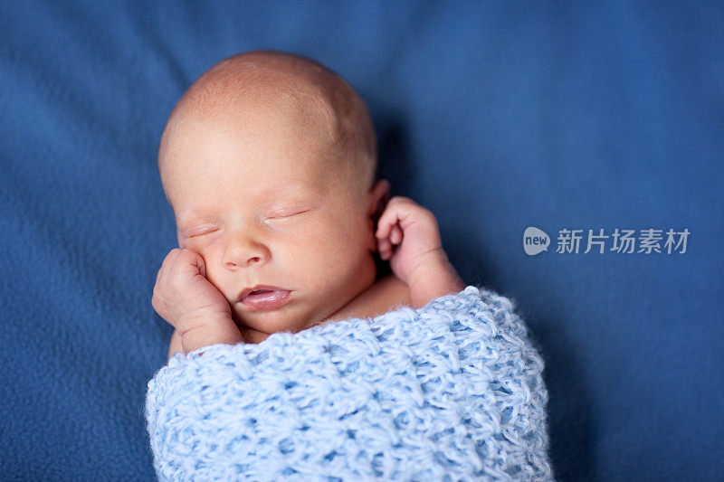 新生男婴在毯子里安静地睡觉