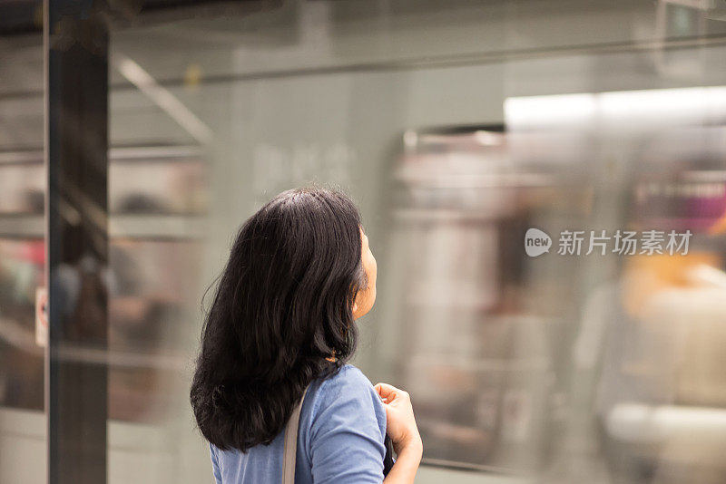 亚洲女人在地铁站等火车