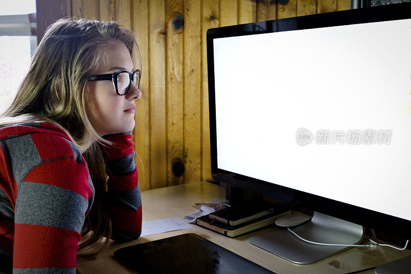 在电脑屏幕前工作的年轻女性或青少年。