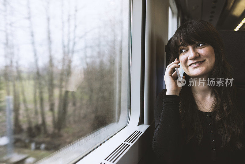 年轻女子在火车上用手机