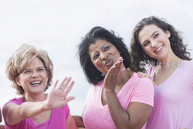 三个身穿粉色衬衫的多民族女子