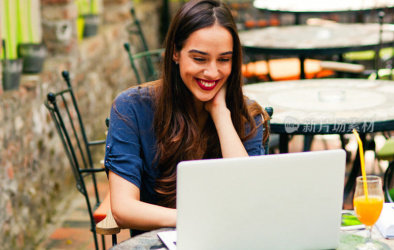 微笑的女人使用笔记本电脑。