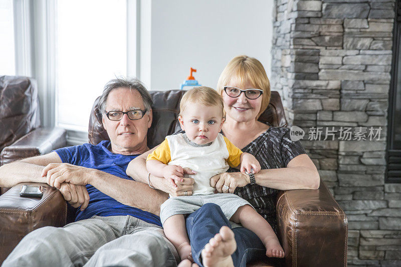 白人祖父母和一岁的孙子坐在一起