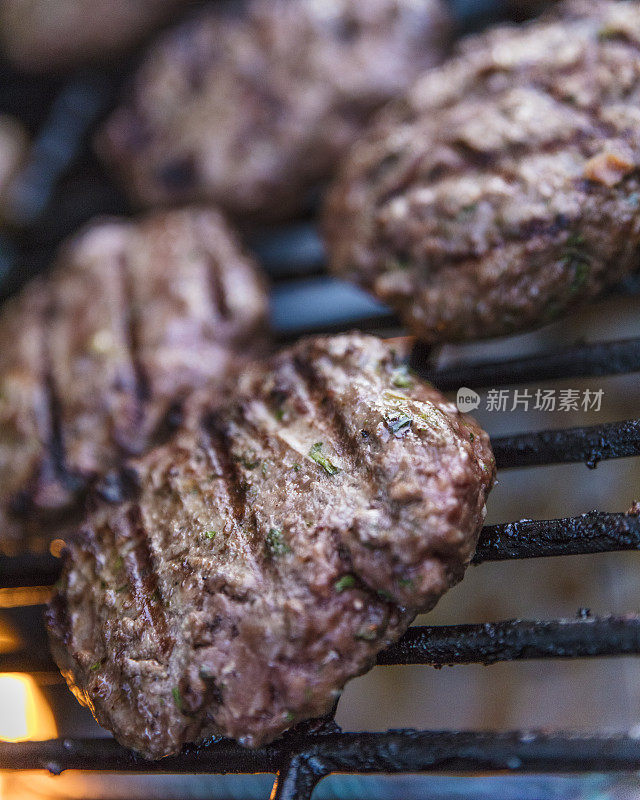 特写牛肉饼在木炭上烹饪汉堡包。