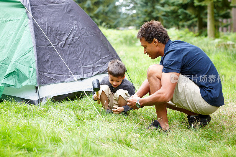 父亲和儿子在为露营搭帐篷