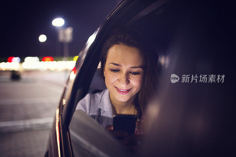 在车里用智能手机的女人