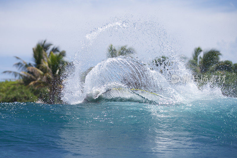 在热带地区，冲浪者在转弯后喷水