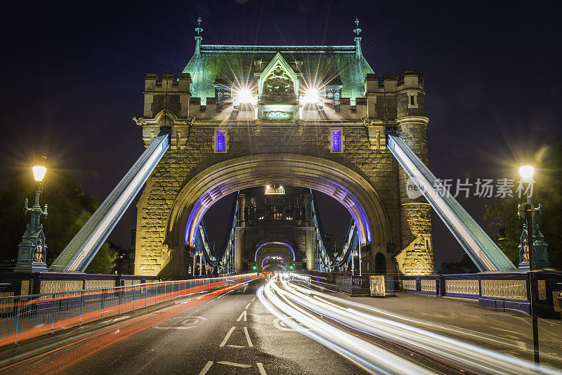伦敦塔桥的交通疾驰穿过明亮的城市灯光英国