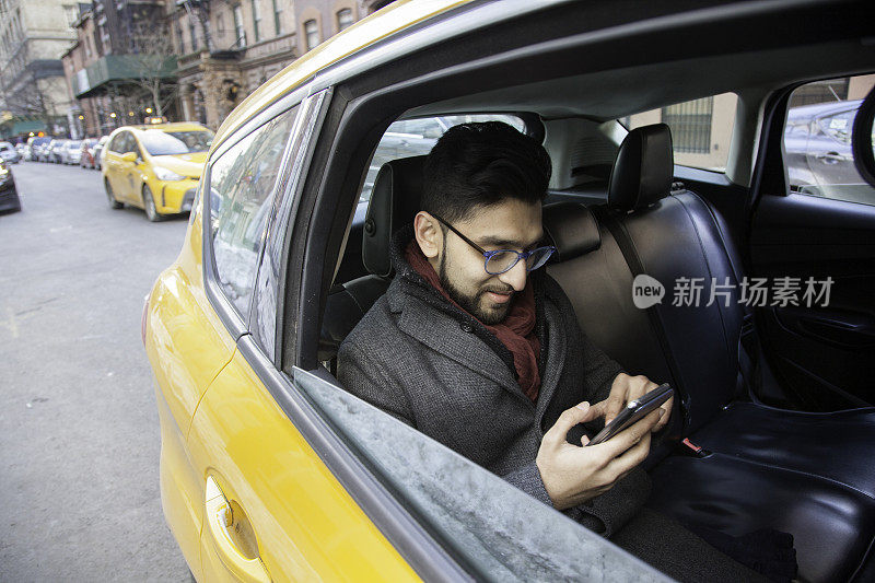 年轻人在出租车上用智能手机
