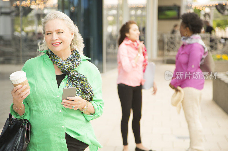 一位成年女性在市区使用手机。