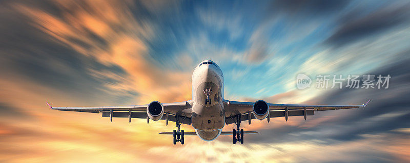 飞机和美丽的天空与运动模糊效果。落日时分，飞机和黄云在模糊的蓝天中飞翔。客运班机。商用飞机。私人飞机