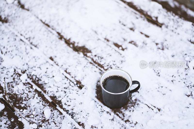 户外，雪白的木桌上放着咖啡杯