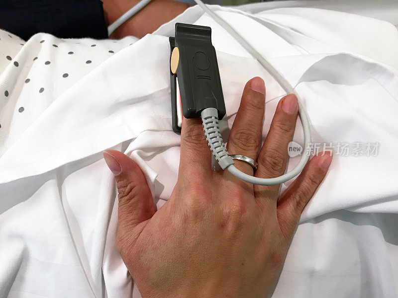 女病人正在医院的急诊室里用指尖或手指脉搏血氧计测氧。