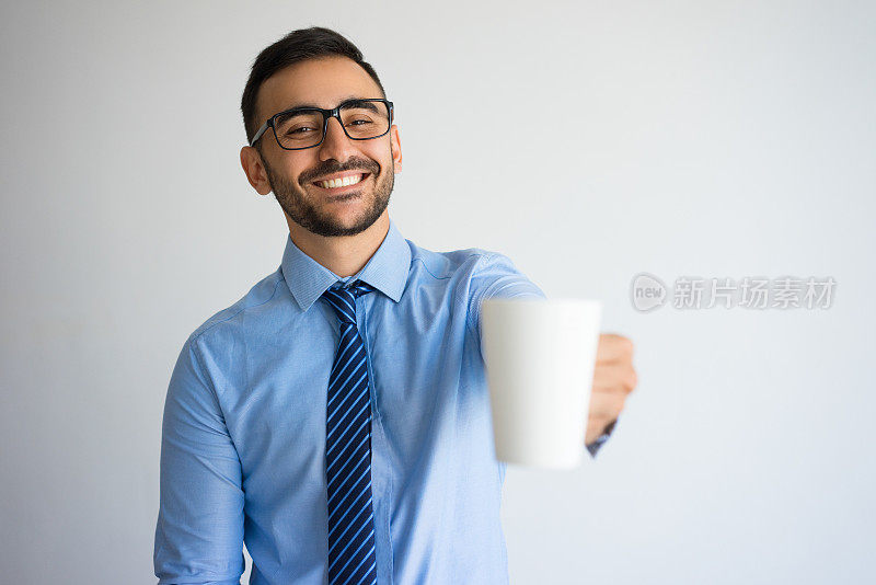 快乐英俊的商人举起一杯茶