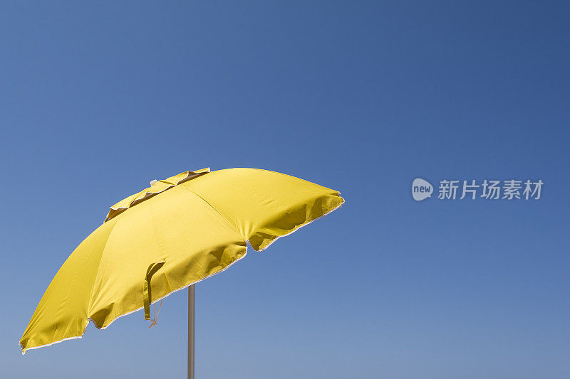 黄色的太阳伞映衬着蓝色的天空