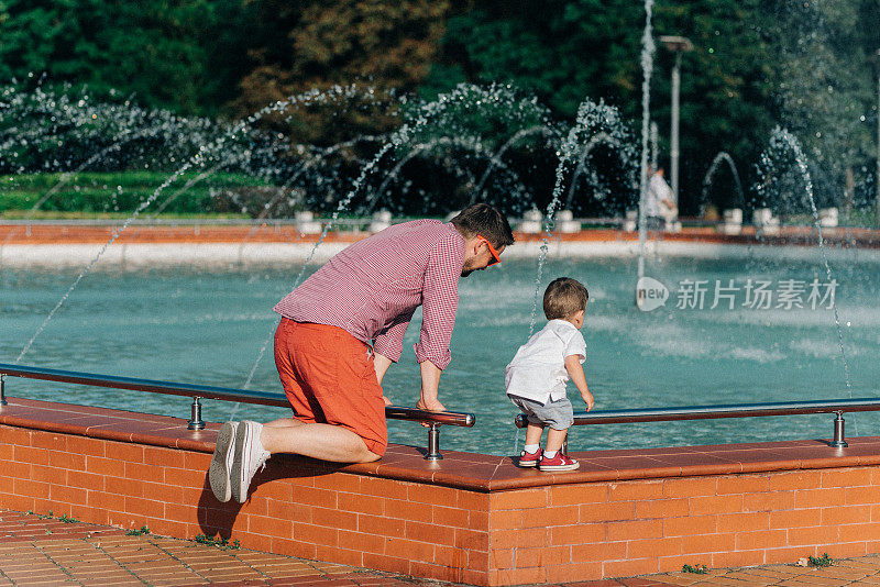 父亲和儿子在看喷泉