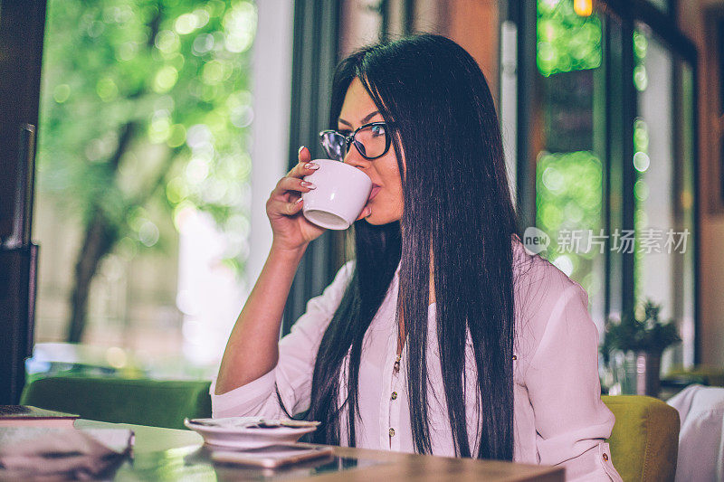 一名年轻女子在休息时间在咖啡厅喝咖啡