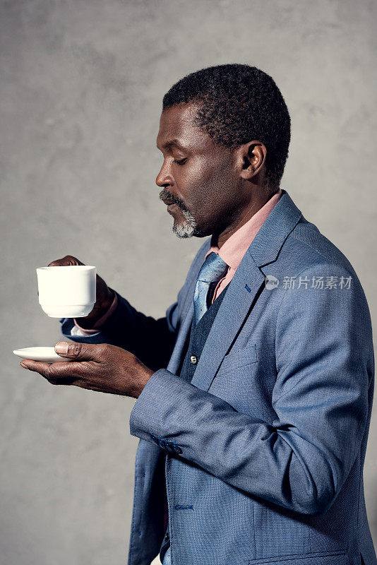 成熟的非裔美国人拿着一杯咖啡