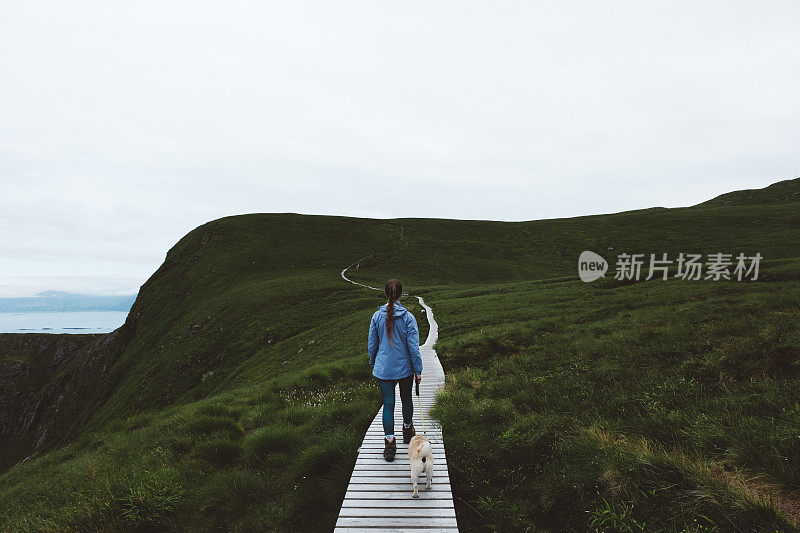 妇女和狗在挪威北部岛屿徒步旅行