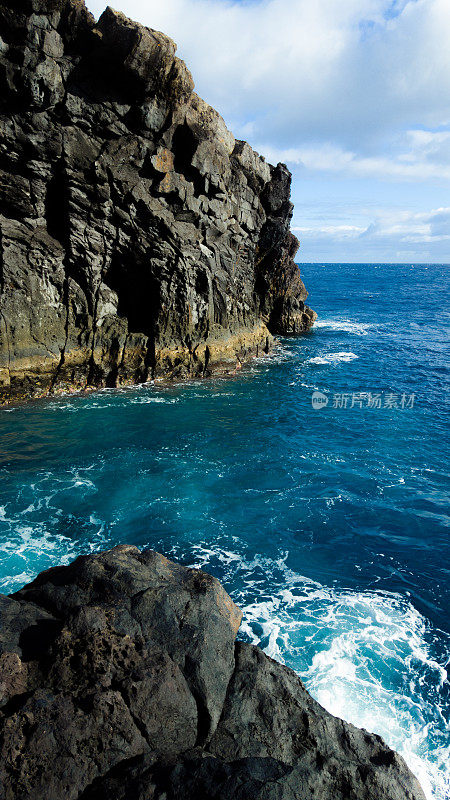 马德拉岛的黑色火山和蓝色的海水