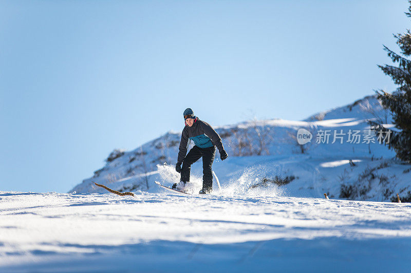 一个年轻人在雪山上滑雪